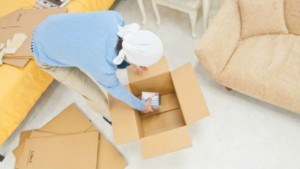 段ボールに荷物を詰める男性